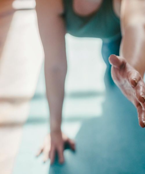 Person practicing a calm yoga movement in a bright room.